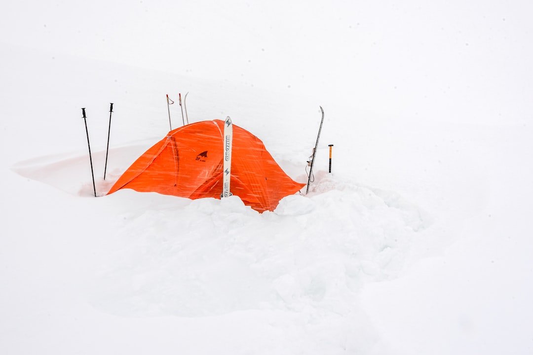 Testing team setting up camp in snowy Arctic landscape with multiple sleeping bags visible